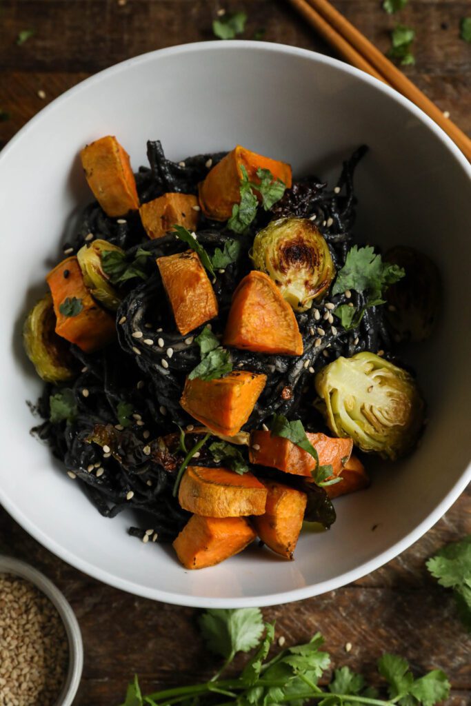 Black Sesame Noodle Bowl served in bowl topped with cilantro and sesame seeds