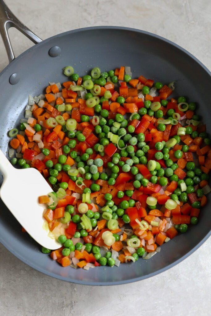 chopped vegetables in skillet with spatula