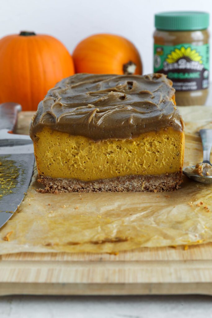 Pumpkin Pie Cheesecake with SunButter Frosting on parchment lined board