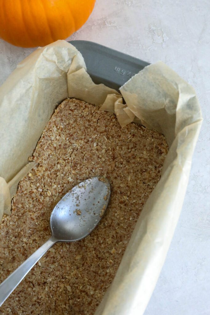 crust for pumpkin pie cheesecake pressed into parchment lined bread pan