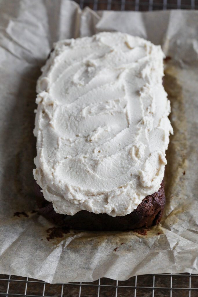 Applesauce Gingerbread Loaf frosted on parchment lined cooling rack