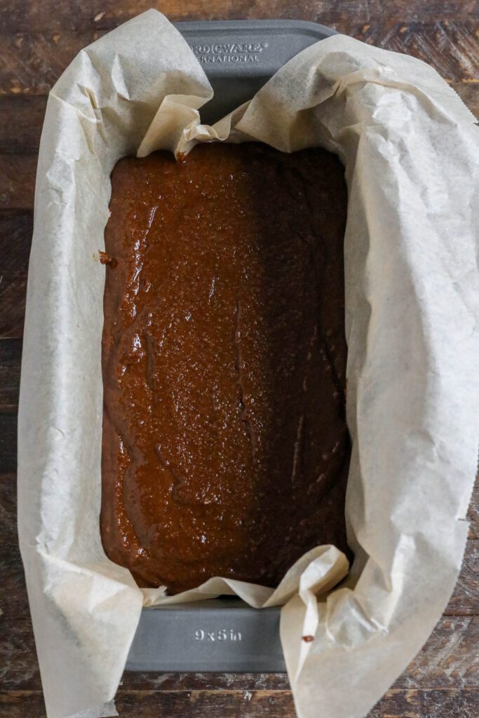 Applesauce Gingerbread Loaf batter in parchment lined loaf pan