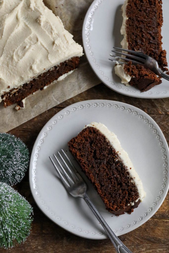 Applesauce Gingerbread Loaf topped with vegan cream cheese frosting served on plates with forks