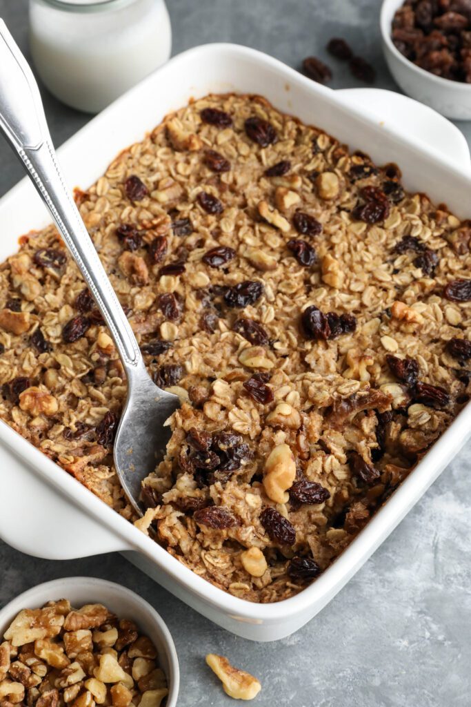 spoon serving Cinnamon Raisin Cookie Baked Oatmeal out of baking dish