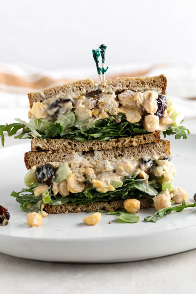 Cranberry Chickpea Salad Sandwich stacked on white plate