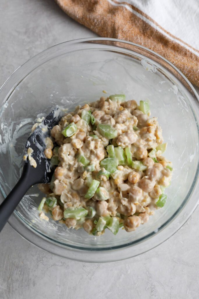 cranberry chickpea salad in glass bowl and spatula 