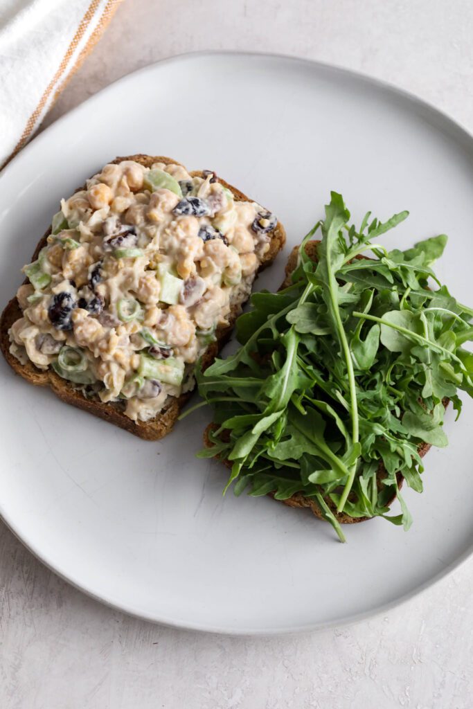 Cranberry Chickpea Salad Sandwich on toasted bread with arugula 
