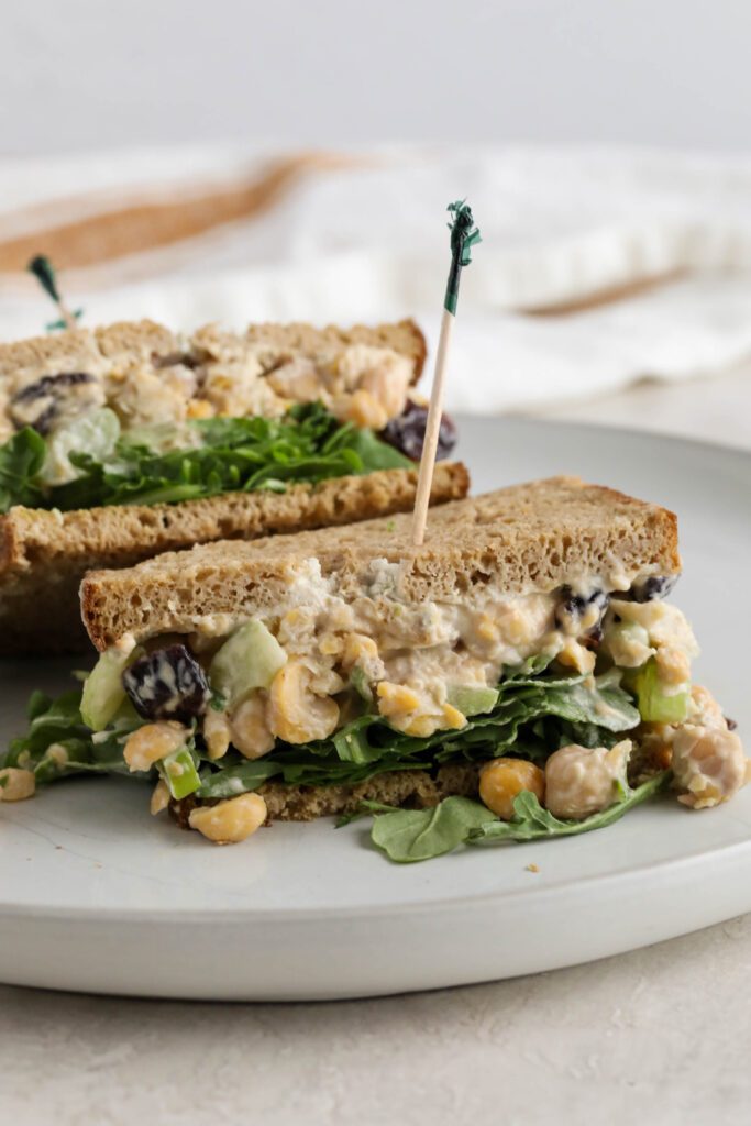 Cranberry Chickpea Salad Sandwich halved and served on white plate