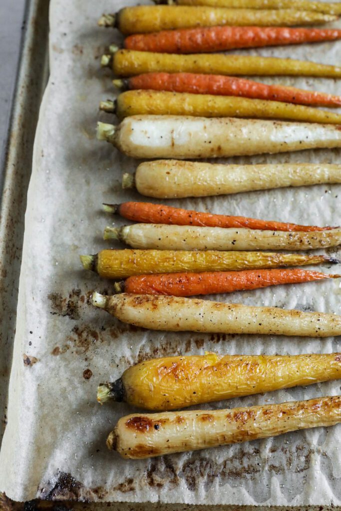 Rainbow carrots roasted on parchment lined baking sheet