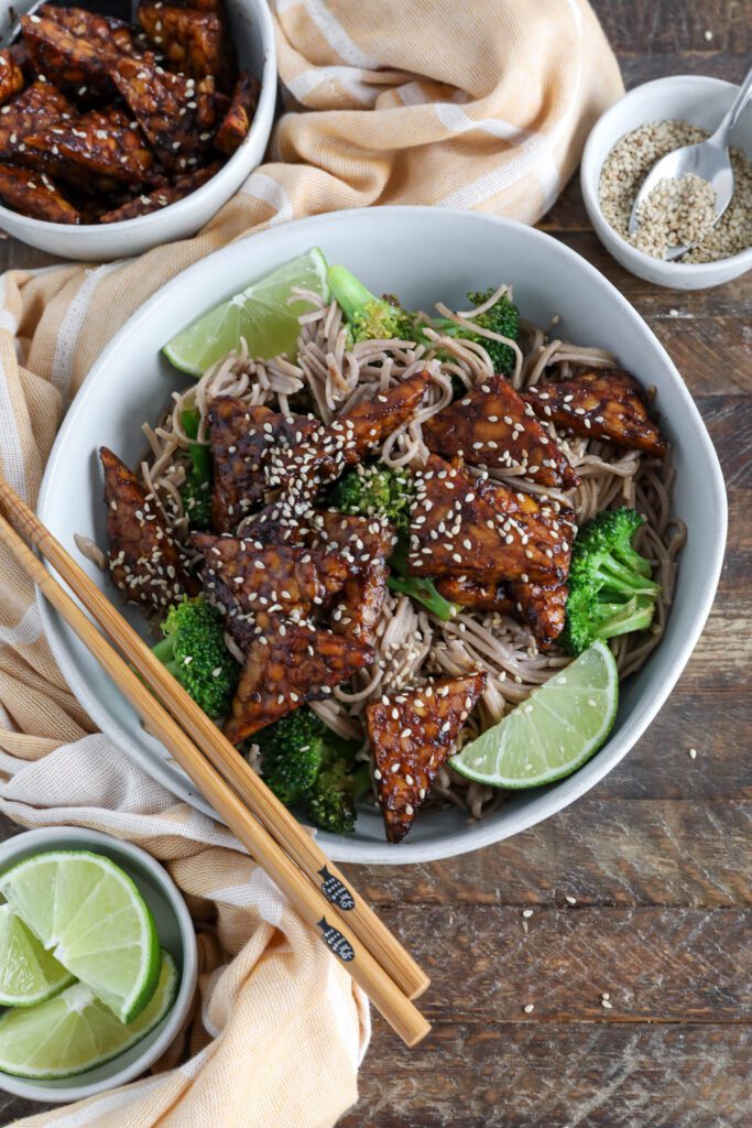 Soba Noodles with Maple Miso Glazed Tempeh served in bowl with chopsticks an sesame seeds