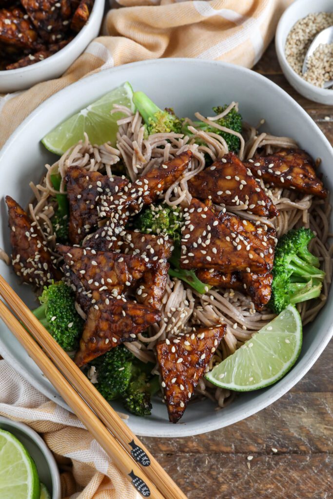 Soba Noodles with Maple Miso Glazed Tempeh served in bowl with chopsticks an sesame seeds