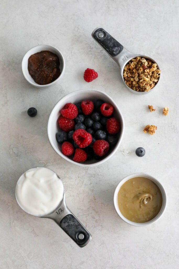 ingredients for yogurt parfait on cement board