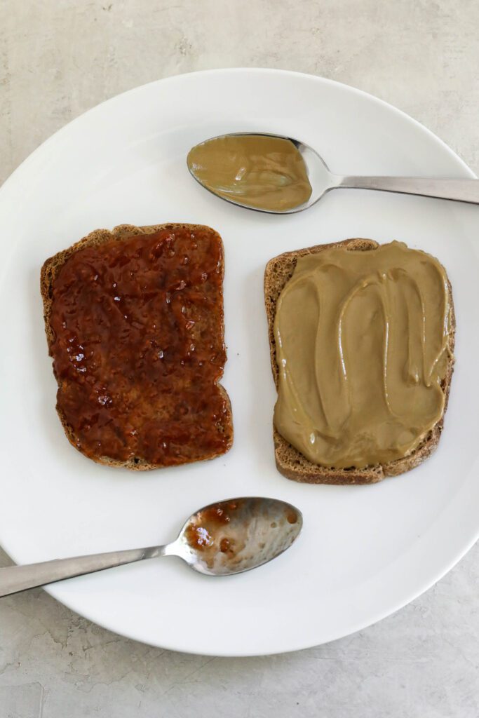 SunButter and Jam spread on two pieces of bread on plate