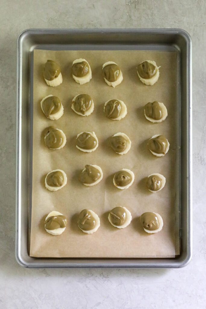 Banana rounds on parchment lined baking sheet topped with SunButter